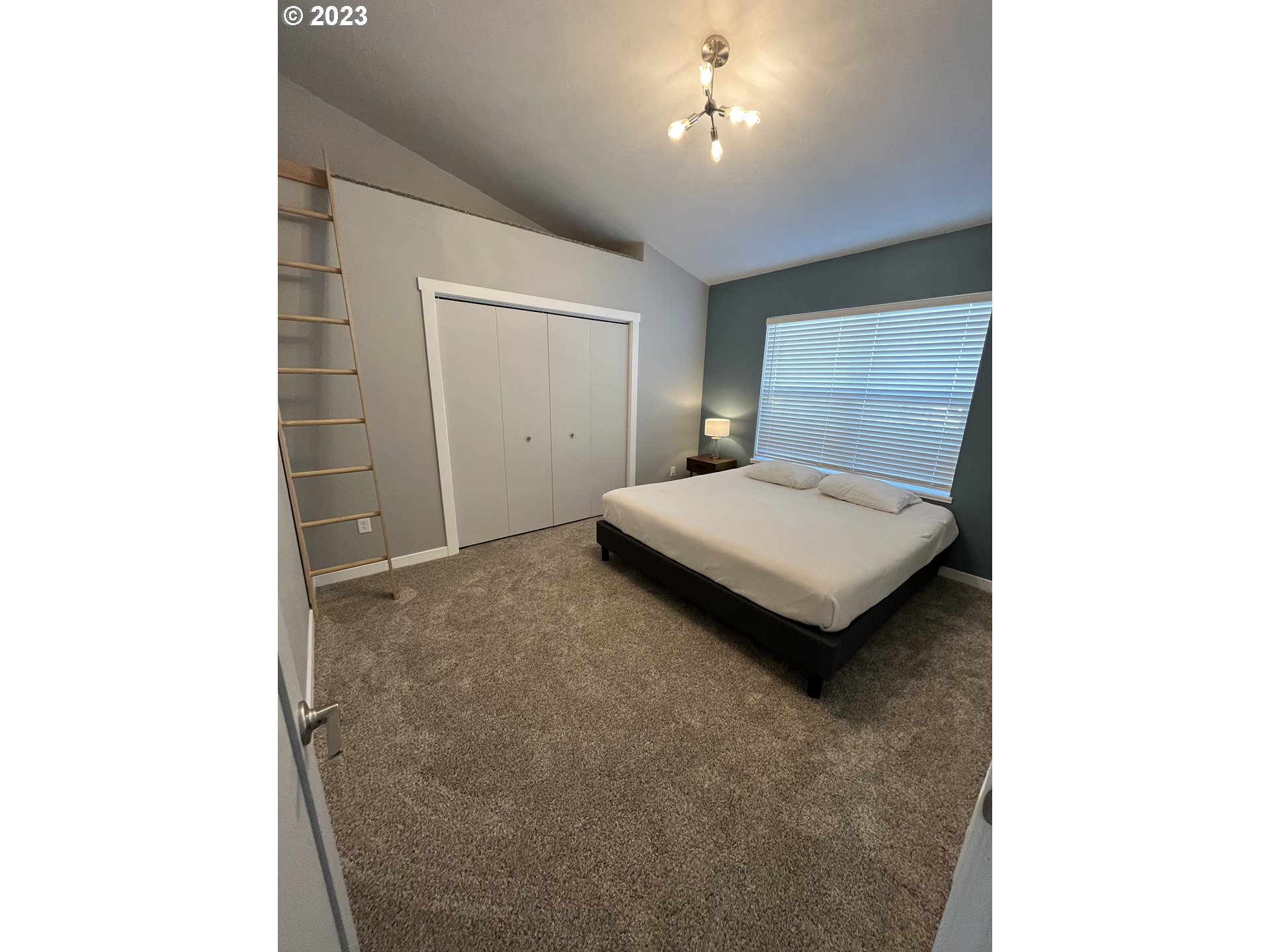 1062 B Street Springfield, OR 97477 - Photo 14 of 33 a bedroom with a bed and a chandelier