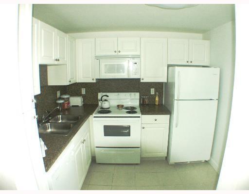 1505 Crescent Circle, Unit C30 Lake Park, FL 33403 - Photo 4 of 5 a kitchen with a refrigerator stove and white cabinets