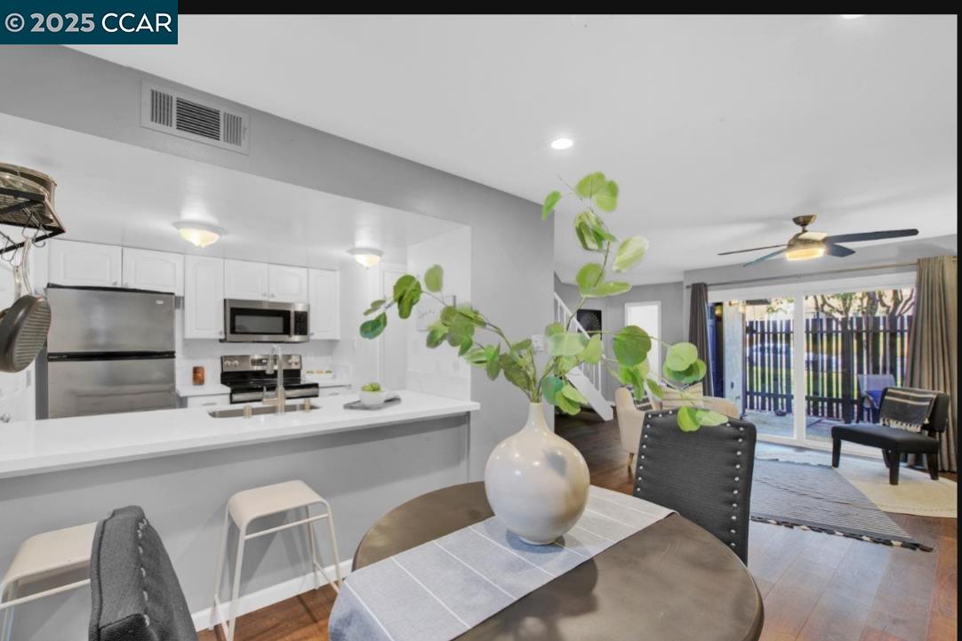 5434 Roundtree Court, Unit C Concord, CA 94521 - Photo 12 of 23 a dining room filled chandelier and wooden floor