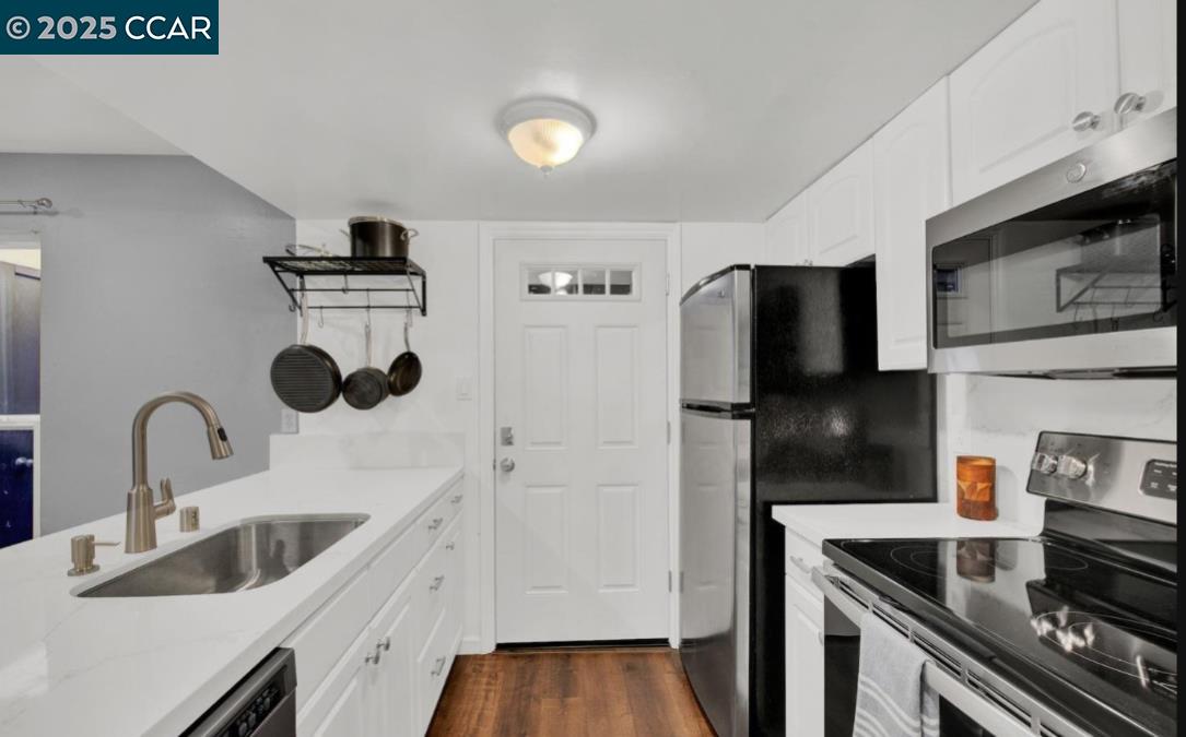 5434 Roundtree Court, Unit C Concord, CA 94521 - Photo 13 of 23 a kitchen with stainless steel appliances a sink a stove and a refrigerator with wooden floor