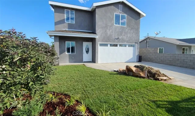a front view of a house with a garden and plants