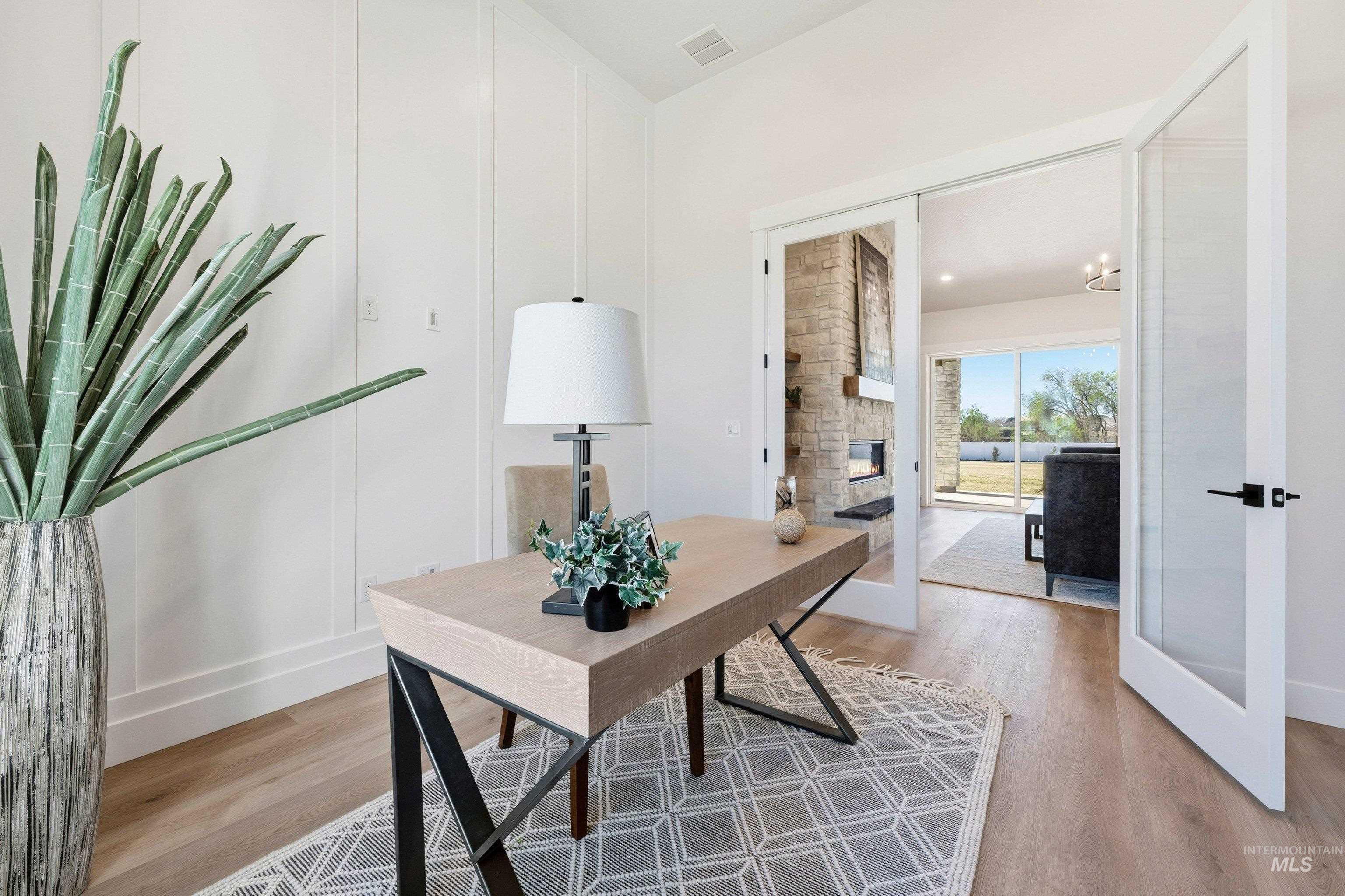24897 Ardmore Court Caldwell, ID 83607 - Photo 28 of 47 Home office with light wood finished floors, a stone fireplace, and french doors