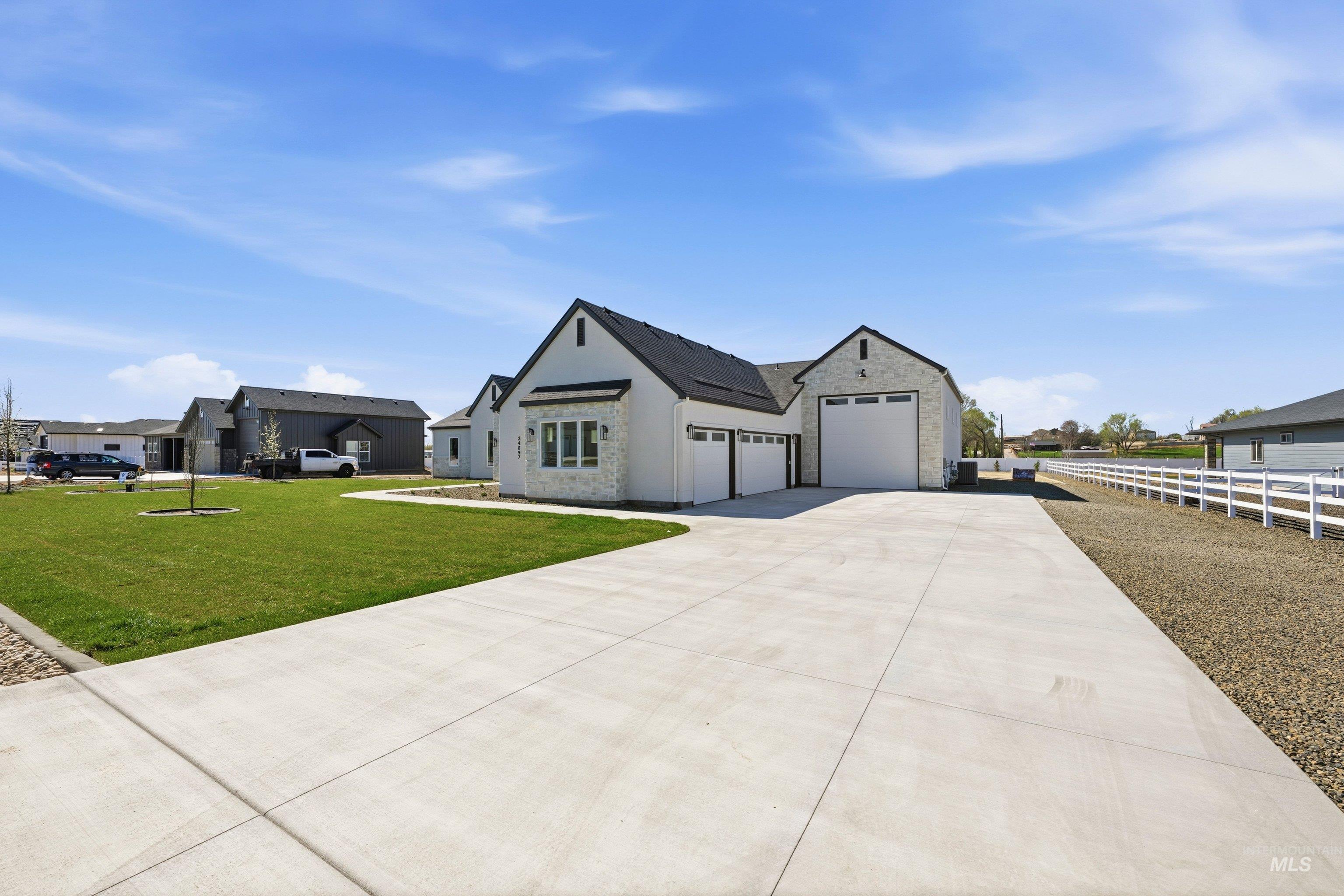 24897 Ardmore Court Caldwell, ID 83607 - Photo 6 of 47 Modern farmhouse with stone siding, concrete driveway, a garage, a residential view, and stucco siding