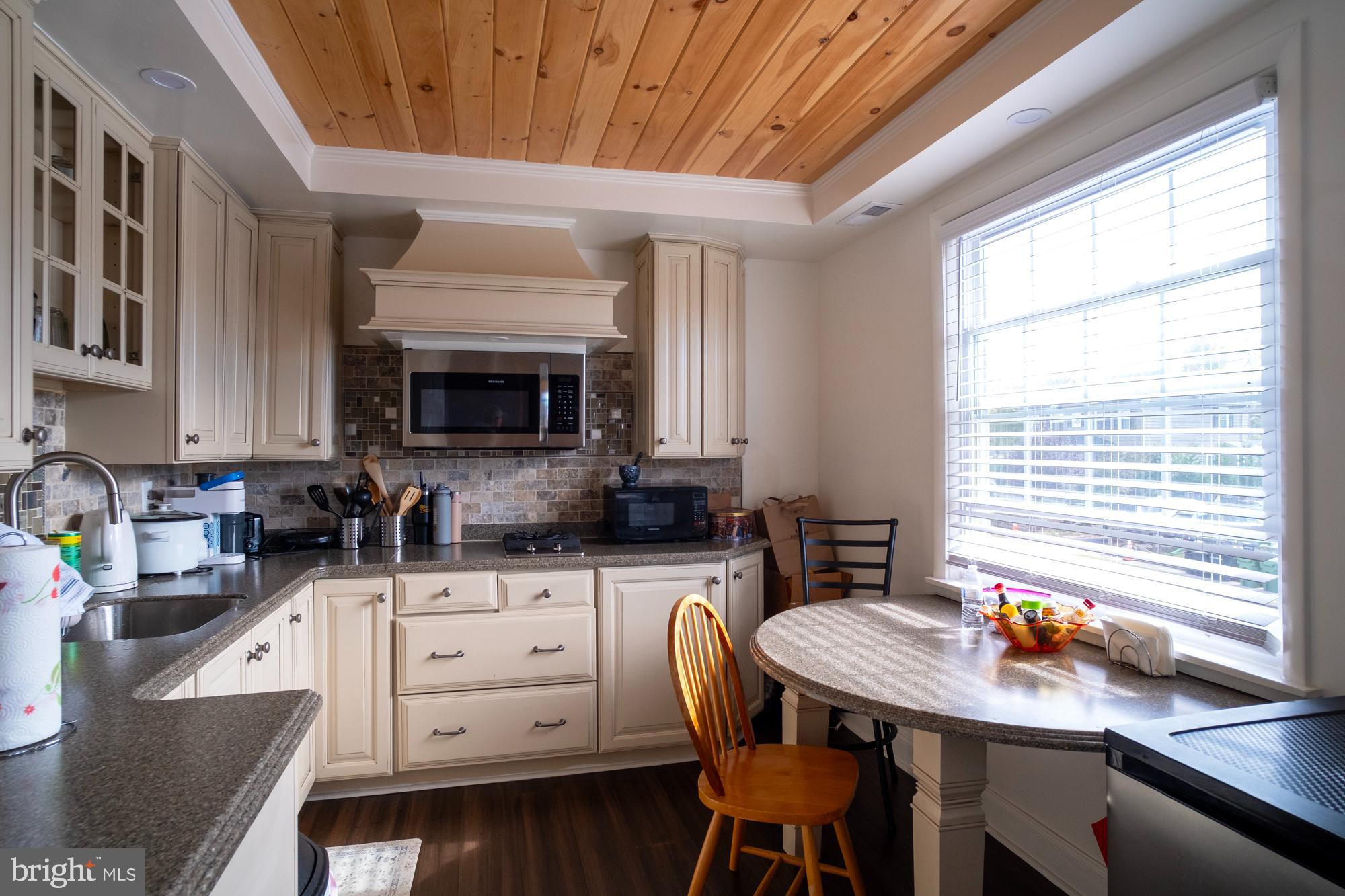 1416 Sulphur Spring Road Halethorpe, MD 21227 - Photo 16 of 42 a kitchen with white cabinets a table and chairs