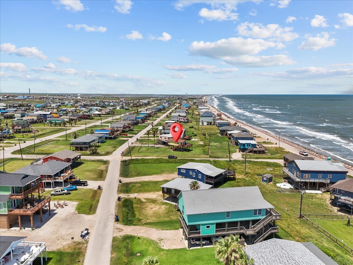 819 Seashell Drive Surfside Beach, TX 77541 - Photo 8 of 27 This coastal property offers stunning ocean views and easy beach access. It's situated in a charming neighborhood with a mix of vibrant homes, providing a serene and picturesque setting ideal for beach lovers.