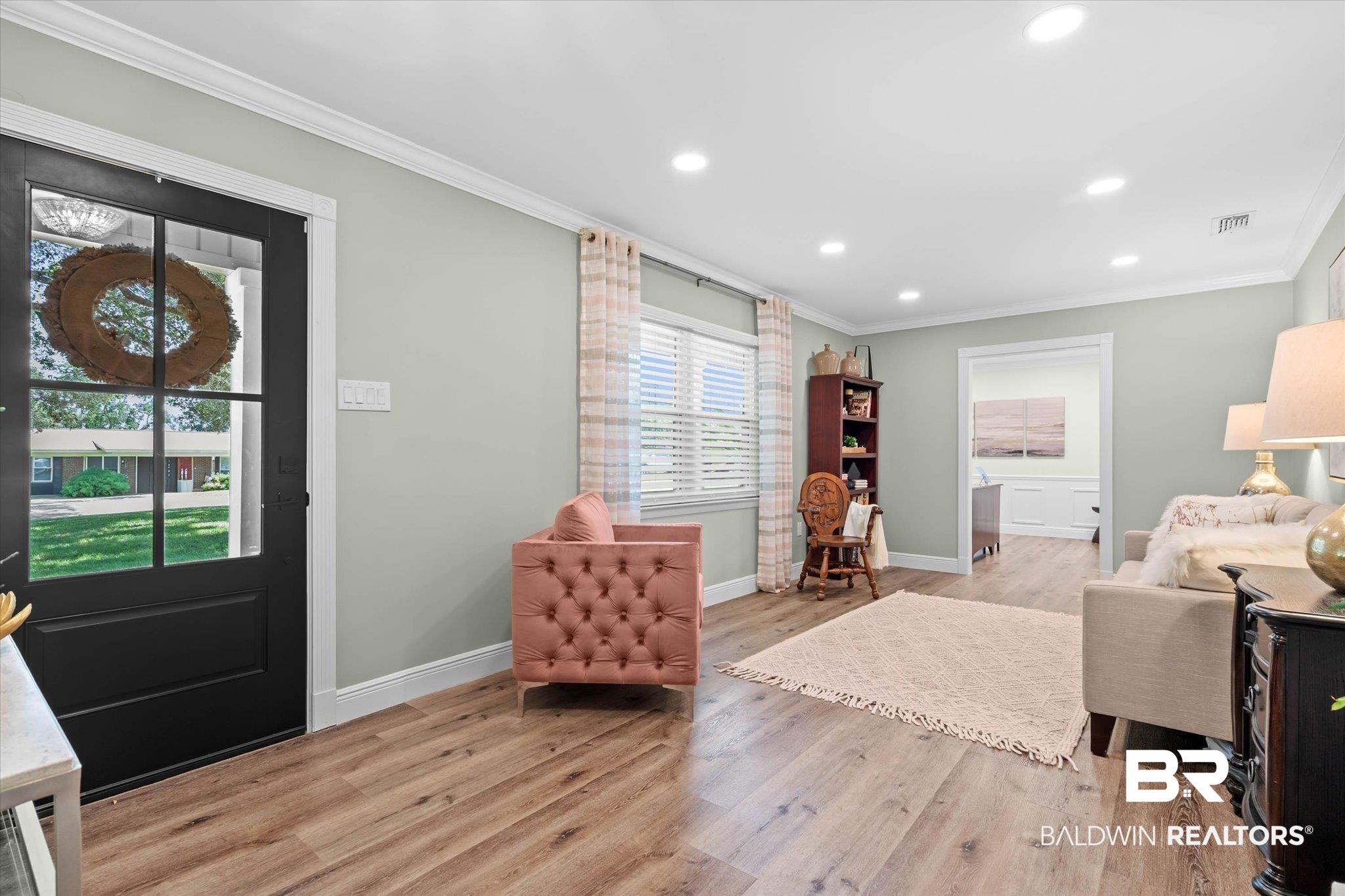 101 Ann Street Daphne, AL 36527 - Photo 3 of 38 Wood-finish flooring throughout, featuring a black paneled door with glass inserts, recessed lighting, white crown molding, and white baseboards