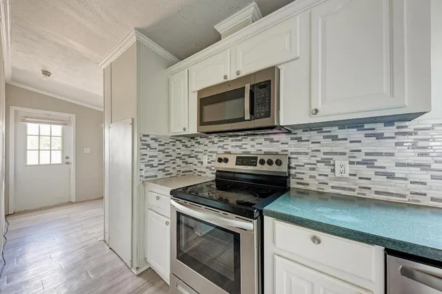 a kitchen with stainless steel appliances a stove microwave and sink