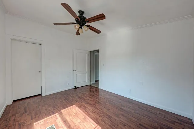 a view of a big room with wooden floor and windows