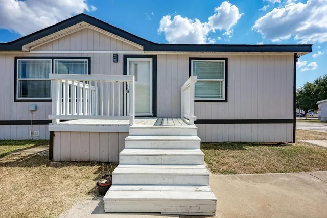 a view of house with large windows and a ceiling fan