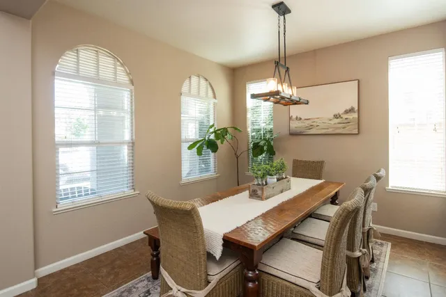 a dining room with furniture a chandelier and wooden floor