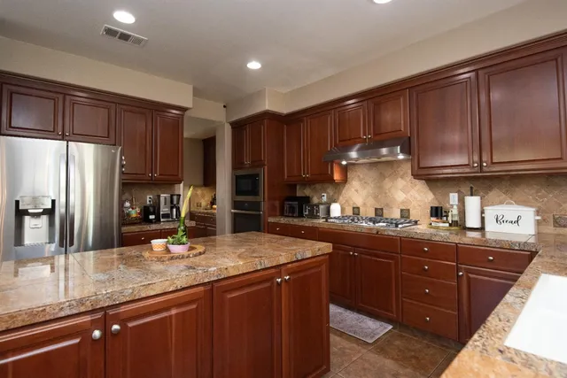 a kitchen with stainless steel appliances granite countertop a sink stove and refrigerator