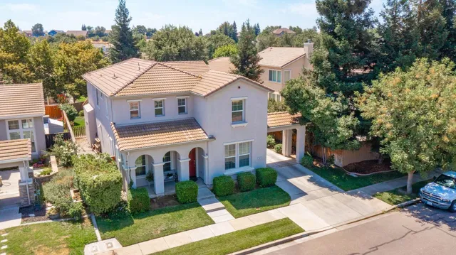 a aerial view of a house with a yard and potted plants