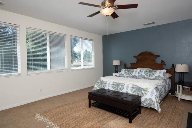 a bedroom with a bed lamp and a window