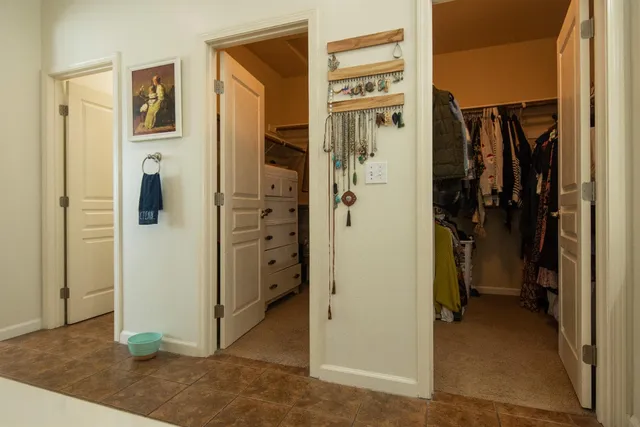 a view of a hallway with closet and bedroom