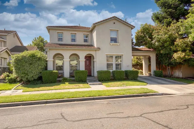 a view of house with yard and large tree in front of it