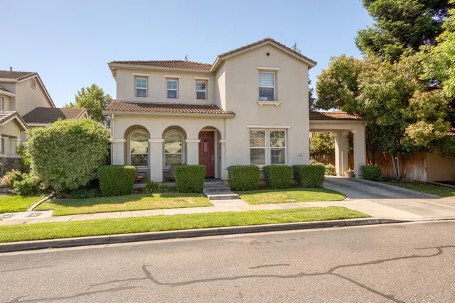 a view of house with yard and large tree in front of it