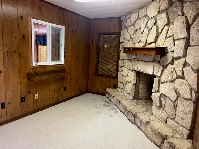a view of a livingroom with wooden floor and a fireplace