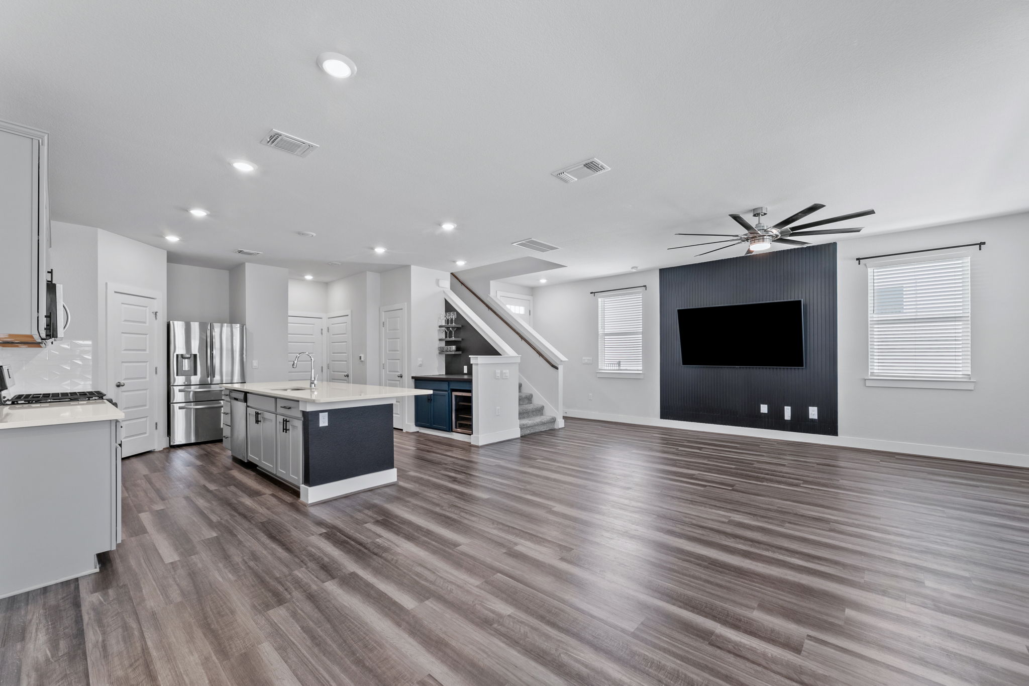 7312 Travertine Spring Drive Austin, TX 78744 - Photo 6 of 32 An open-concept living space with a contemporary kitchen and a grand staircase.