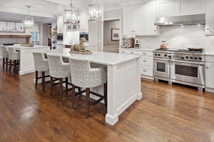 422 Sunset Ridge Road Northfield, IL 60093 - Photo 5 of 52 a kitchen with stainless steel appliances granite countertop a stove top oven a sink dishwasher and a dining table with wooden floor