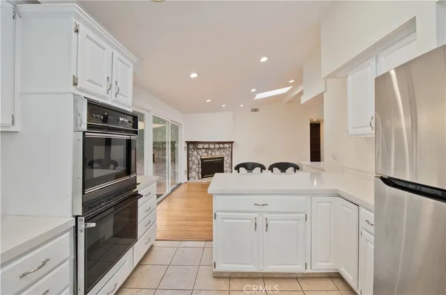a kitchen with kitchen island white cabinets and refrigerator