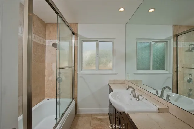 a bathroom with a tub sink and mirror