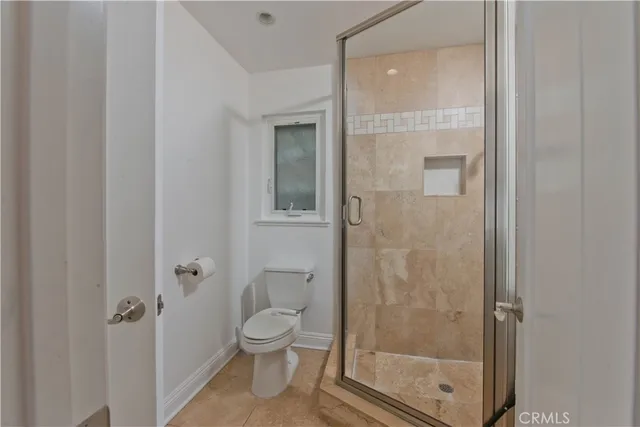 a bathroom with a toilet and a shower