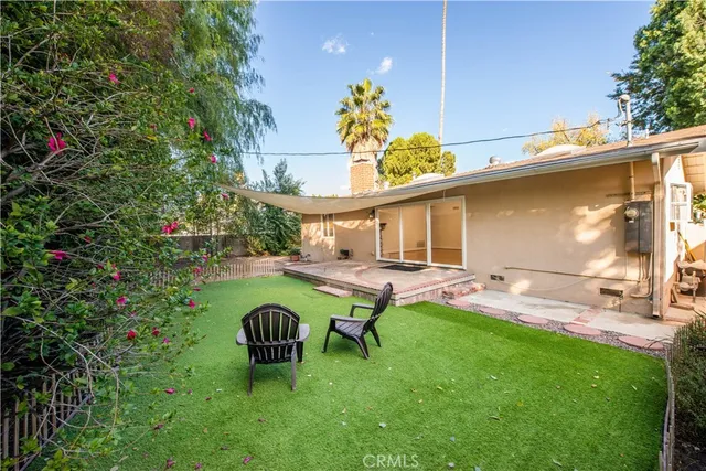 a view of a backyard with table and chairs and potted plants
