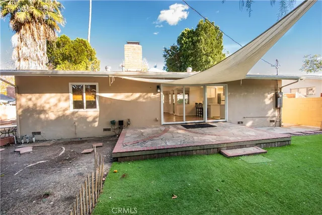a view of a house with backyard and sitting area