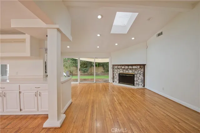 a view of an empty room with a fireplace and a window