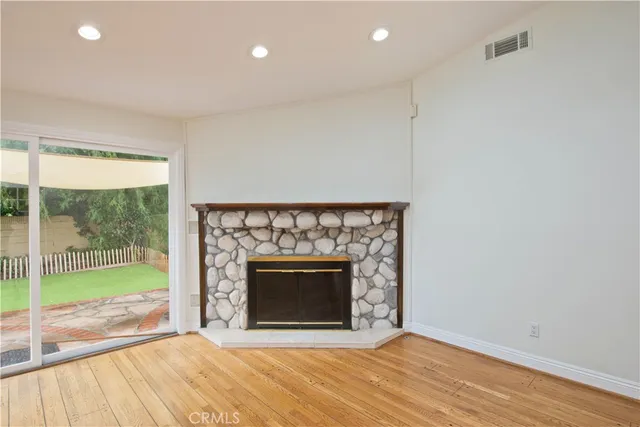 a view of empty room with wooden floor and fireplace