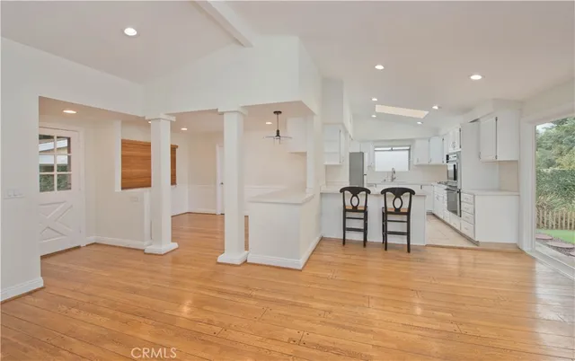 a view of kitchen with refrigerator and wooden floor