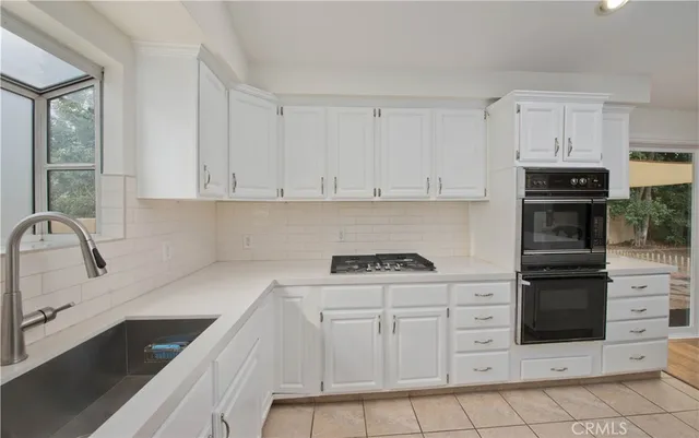 a kitchen with granite countertop a stove sink and cabinets
