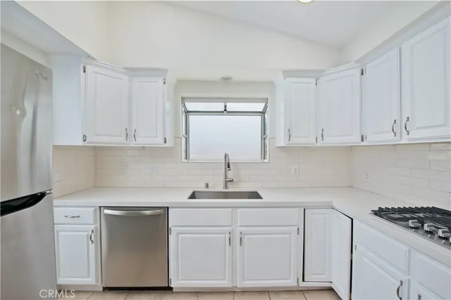a kitchen with white cabinets and white appliances