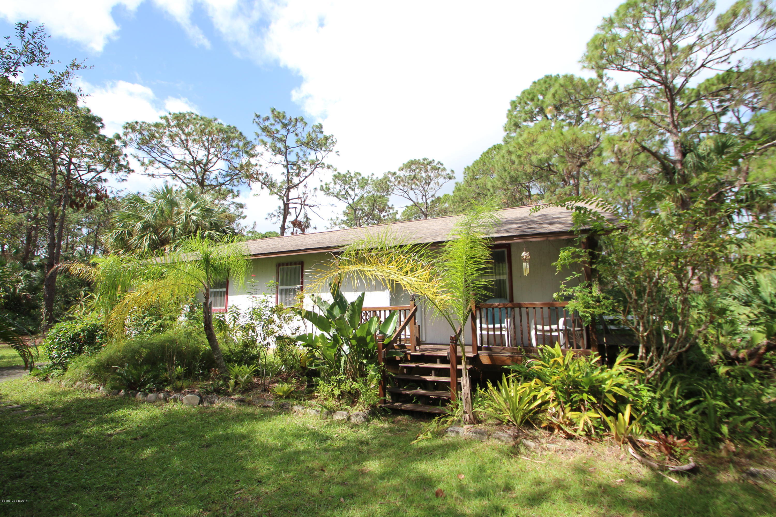 1666 Emmaus Road Northwest Palm Bay, FL 32907 - Photo 1 of 15 a view of a chair and table in the garden in front of house