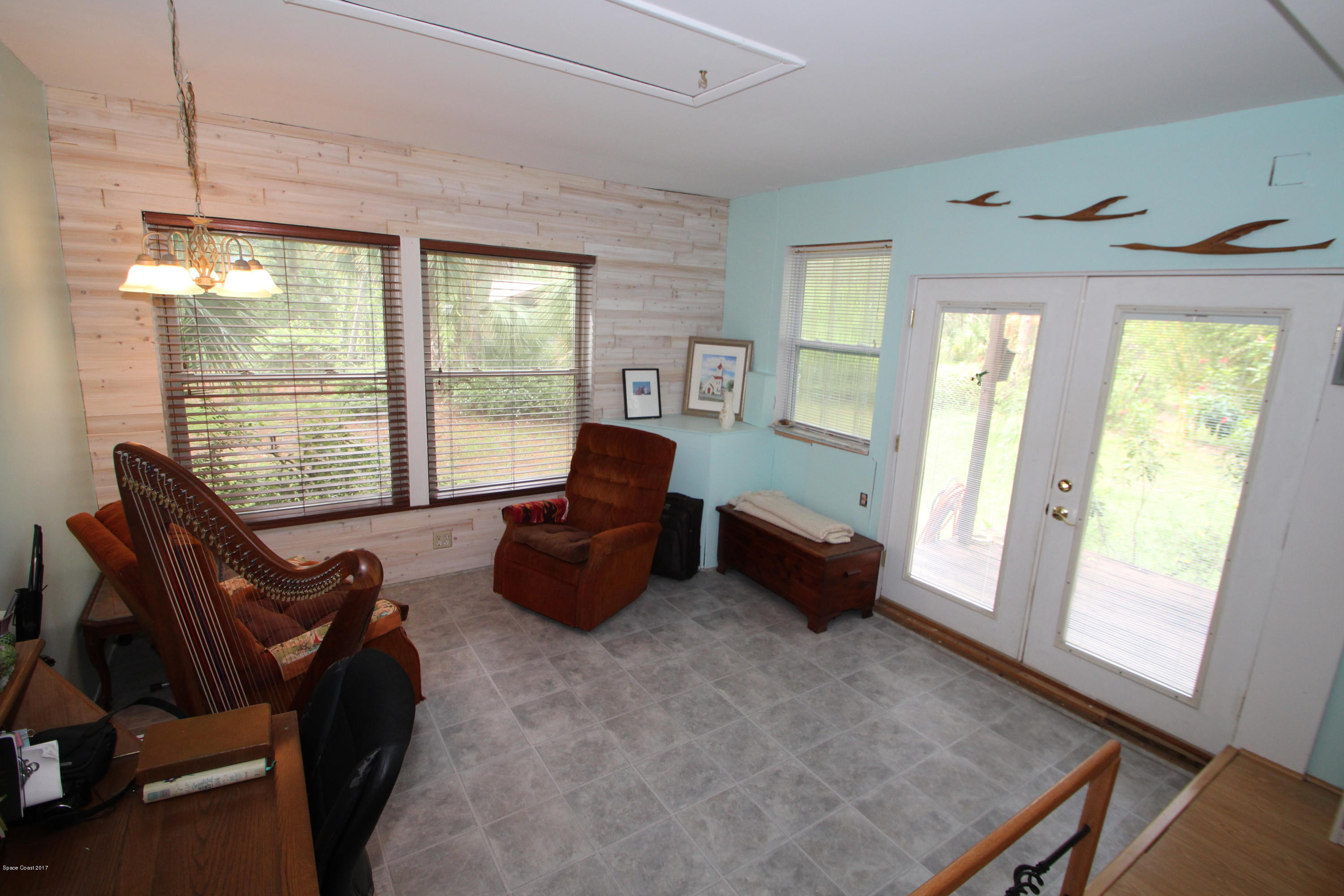 1666 Emmaus Road Northwest Palm Bay, FL 32907 - Photo 10 of 15 a living room with furniture and a floor to ceiling window