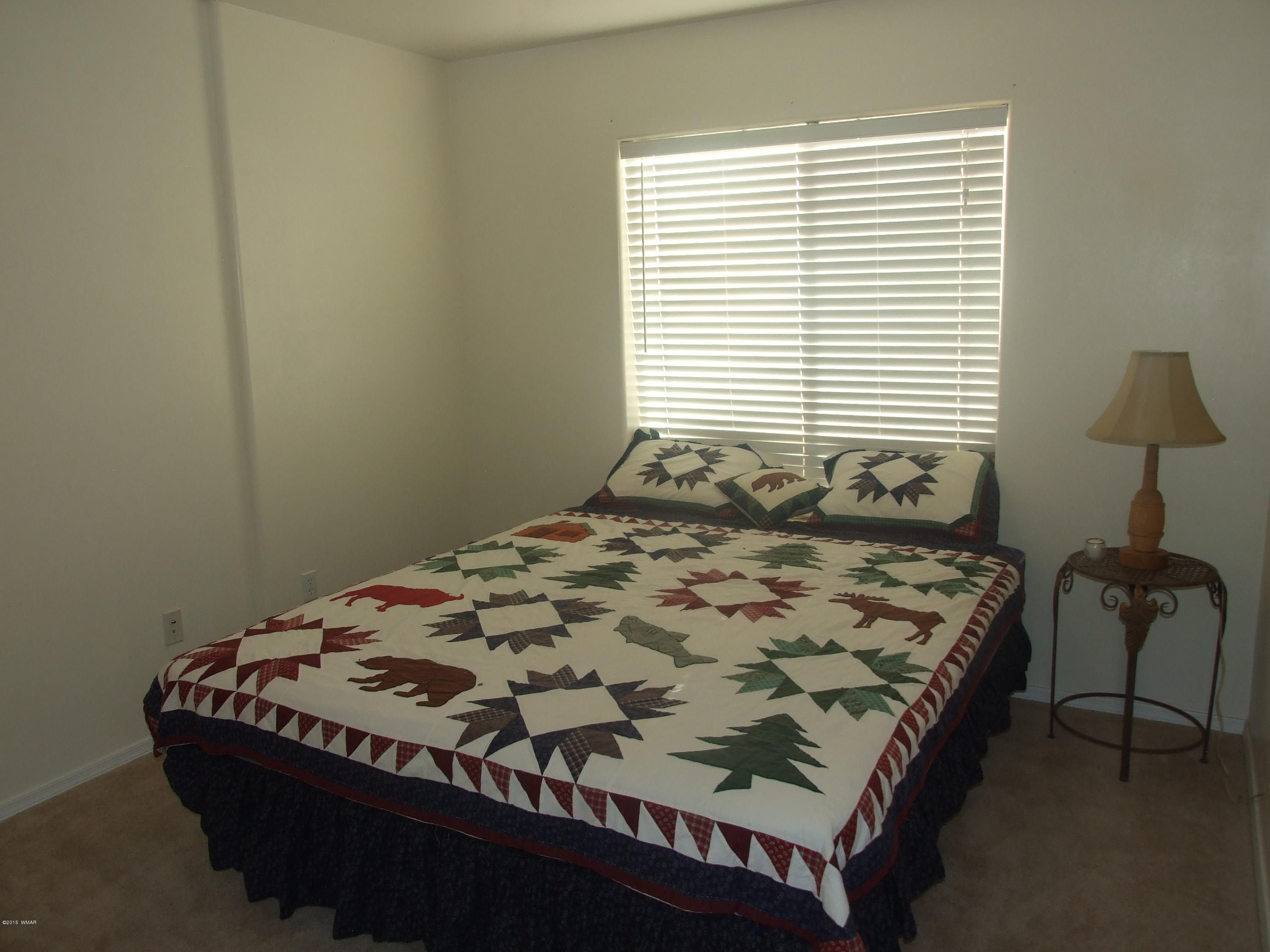 2887 South Bourdon Ranch Road Taylor, AZ 85939 - Photo 16 of 24 a bed sitting in a bedroom next to a window