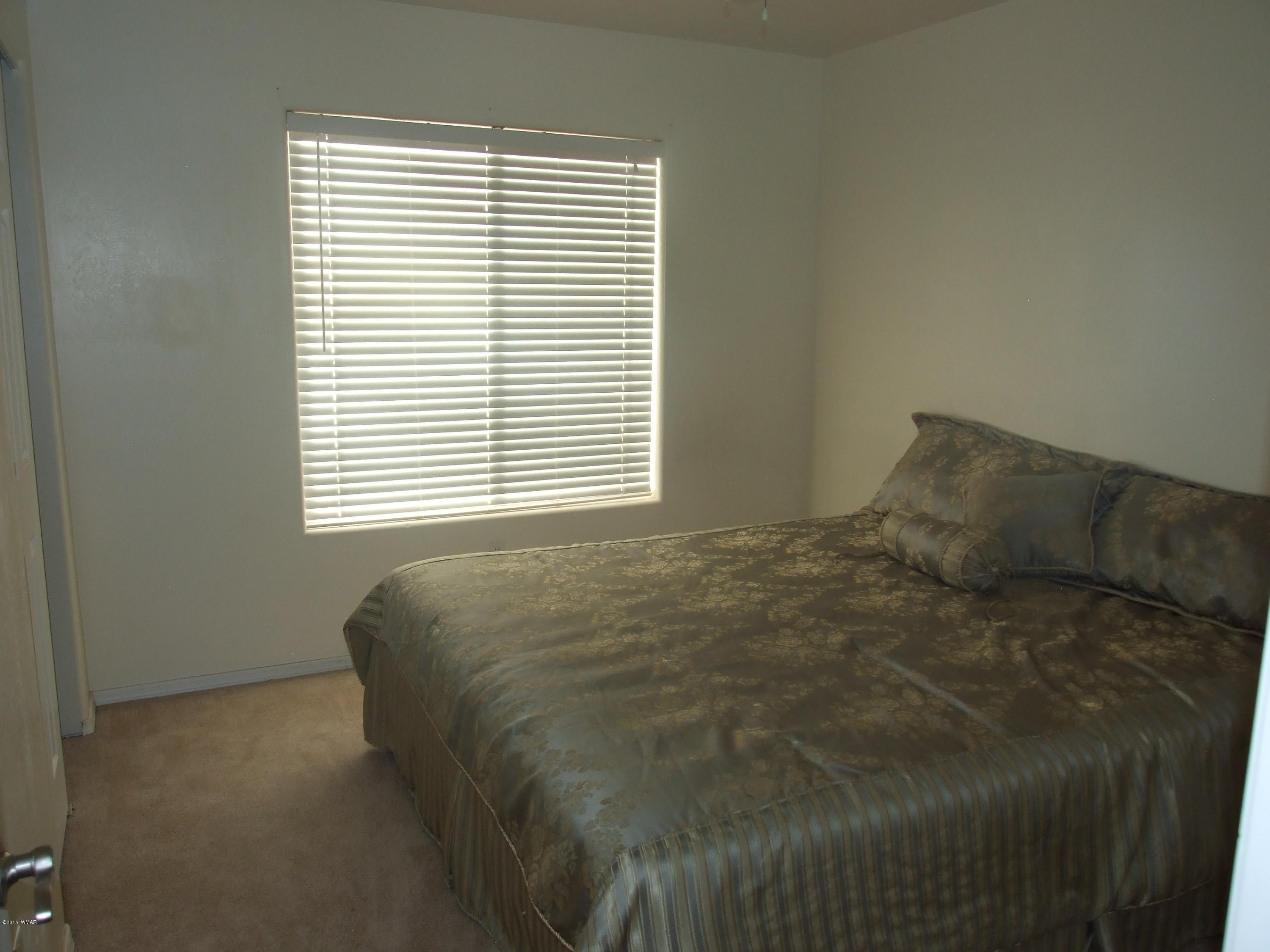 2887 South Bourdon Ranch Road Taylor, AZ 85939 - Photo 17 of 24 a bed sitting in a bedroom next to a window