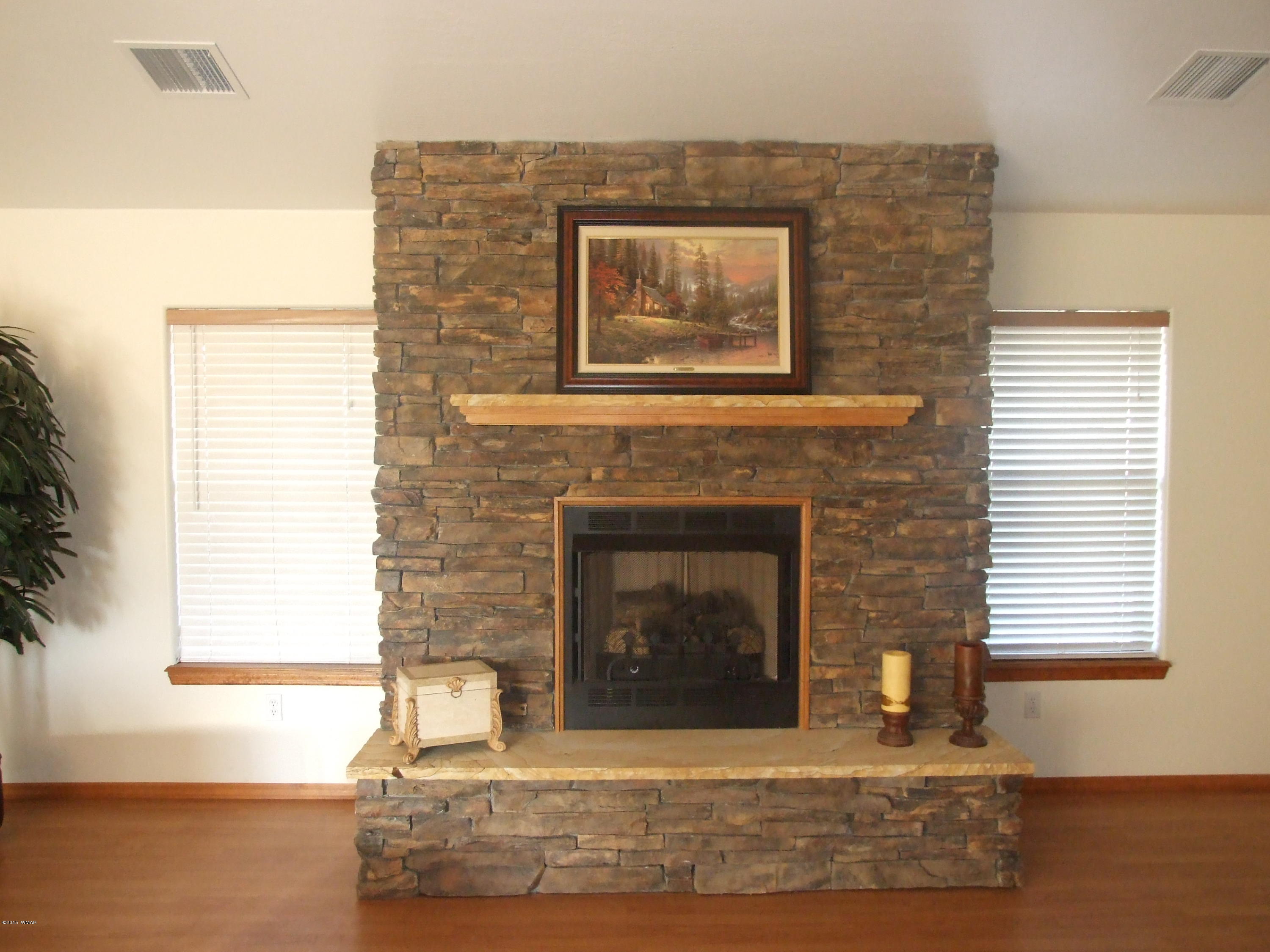 2887 South Bourdon Ranch Road Taylor, AZ 85939 - Photo 6 of 24 a living room with fireplace and a wooden floor