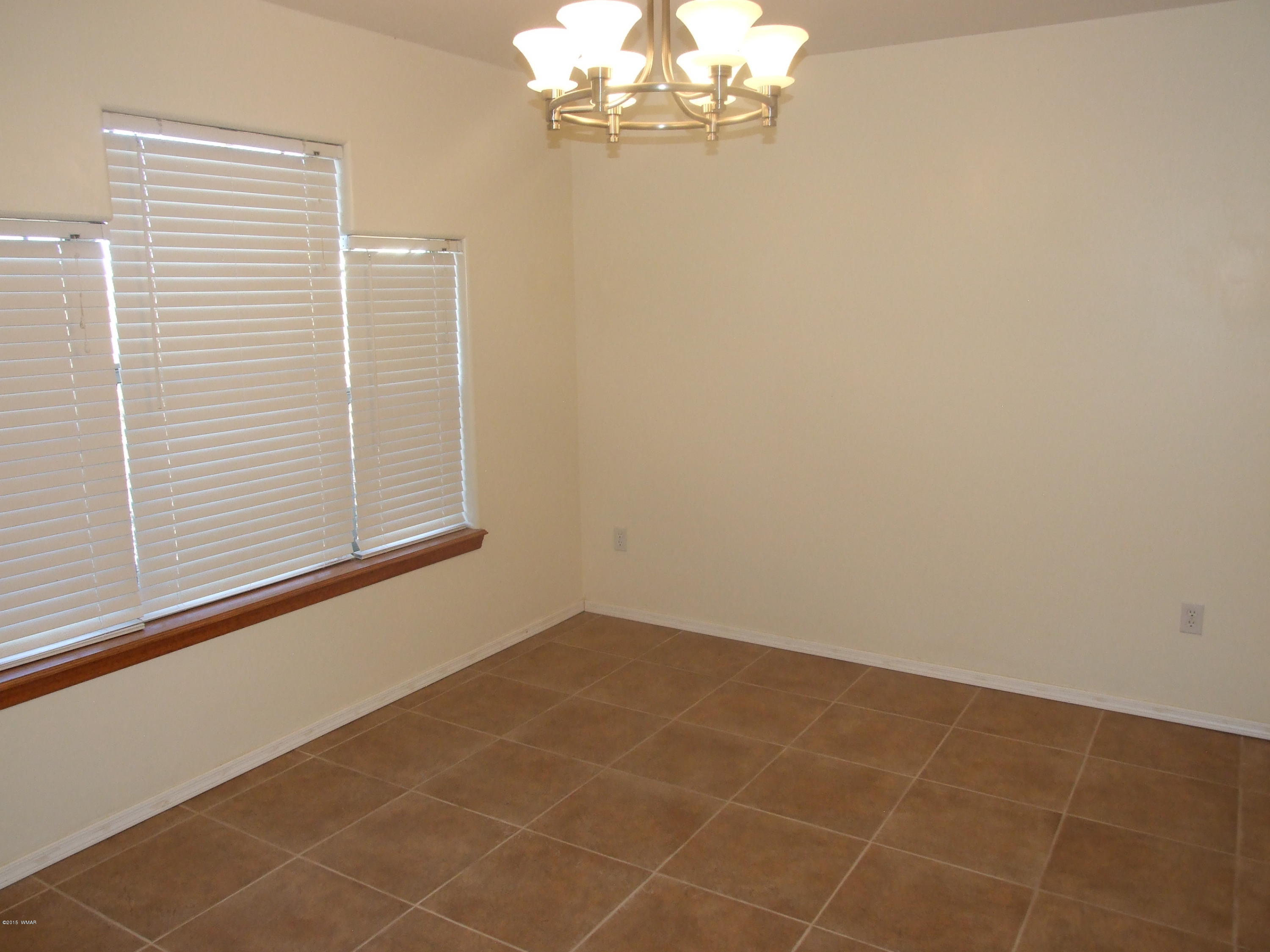 2887 South Bourdon Ranch Road Taylor, AZ 85939 - Photo 8 of 24 a view of a livingroom with an empty space a chandelier and window