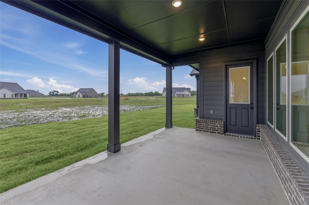 2208 Continent Court Krum, TX 76249 - Photo 22 of 26 Concrete covered patio with recessed lighting, dark siding, and a glass-paneled exterior door