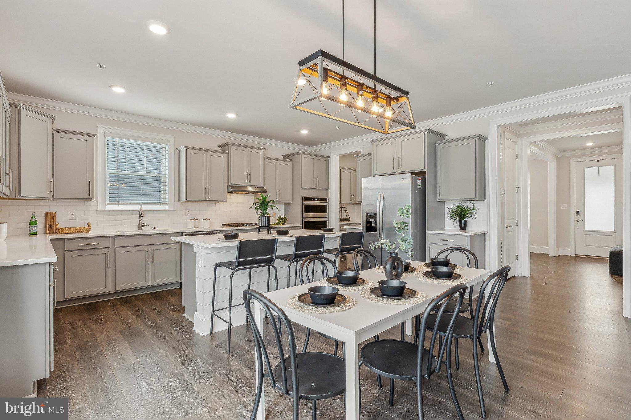 2841 Broad Wing Drive Odenton, MD 21113 - Photo 12 of 71 a kitchen with a dining table chairs sink and cabinets