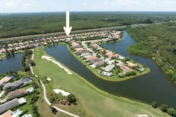 an aerial view of a house with a yard and green space