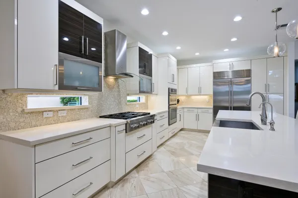 a kitchen with stainless steel appliances granite countertop a sink and a stove
