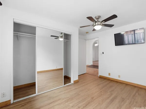 a view of a big room with windows and chandelier fan