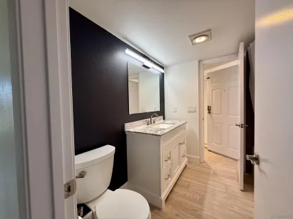 a bathroom with a sink and mirror with toilet