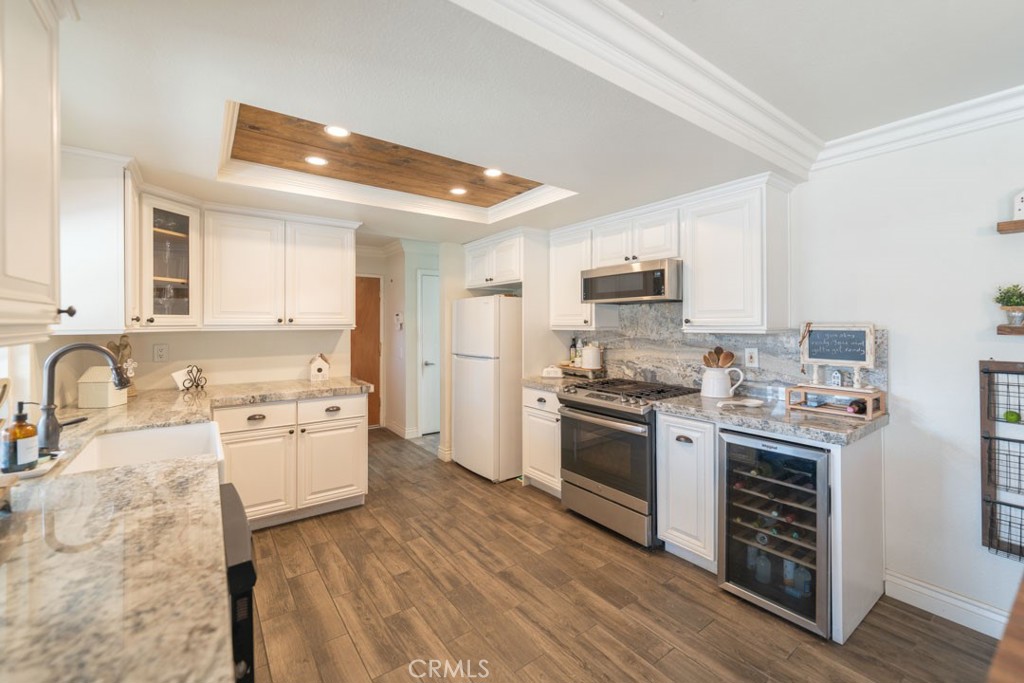 8636 Rancho Cerona Drive Paramount, CA 90723 - Photo 14 of 48 a kitchen with stainless steel appliances granite countertop a stove top oven a sink dishwasher and a refrigerator