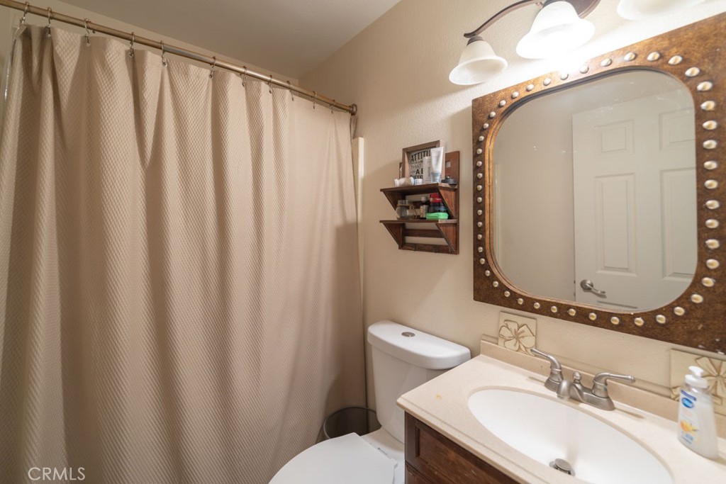 8636 Rancho Cerona Drive Paramount, CA 90723 - Photo 30 of 48 a bathroom with a sink mirror and toilet