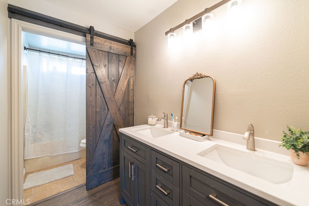 8636 Rancho Cerona Drive Paramount, CA 90723 - Photo 36 of 48 a bathroom with a double vanity sink and a mirror
