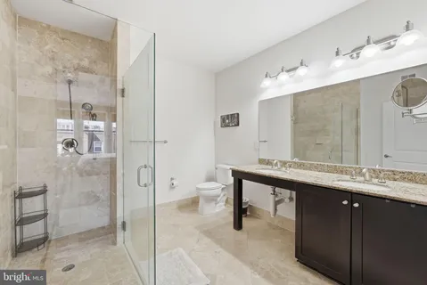 a bathroom with a double vanity sink mirror and shower