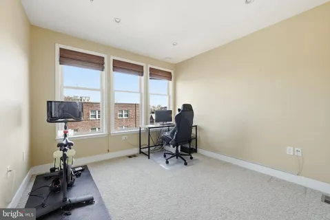 a view of a workspace with furniture and a window